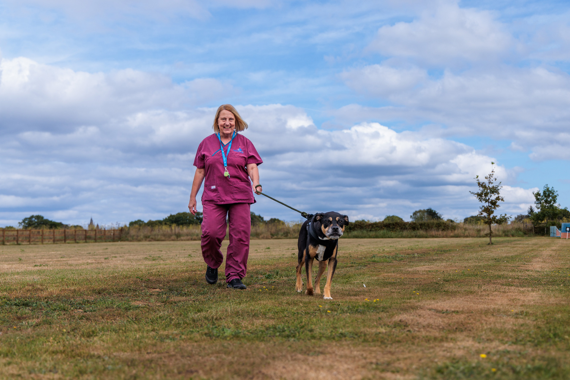 Veterinary care assistant walking a dog outside